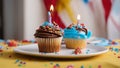 birthday cake with candles A realistic scene of a birthday cupcake with a candle on a white plate. The cupcake is blue