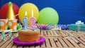 Birthday 12 cake with candles on rustic wooden table with background of colorful balloons, gifts, plastic cups and candies
