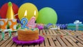 Birthday 24 cake with candles on rustic wooden table with background of colorful balloons, gifts, plastic cups and candies Royalty Free Stock Photo