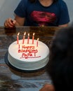 Birthday Cake for Dad written `Happy Birthday Papa` on the table. Burning candle on cake