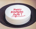 Birthday Cake for Dad written `Happy Birthday Papa` on the table. Burning candle on cake