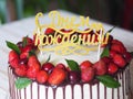 Birthday cake decorated with chocolate and red berries, top with strawberries and cherries on white cream Royalty Free Stock Photo