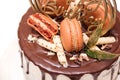 Birthday cake decorated with golden macaroons, top view. Elegant naked cake topped by chocolate. Birthday party celebration