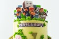 Birthday cake for a fan of Minecraft game on white background. Cake for a gameboy decorated with edible green grass