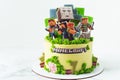 Birthday cake for a fan of Minecraft game on white background. Cake for a gameboy decorated with edible green grass