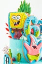 Birthday cake for a fan of SpongeBob SquarePants on white background. Nautical turquoise bunk cake with characters of animated Royalty Free Stock Photo