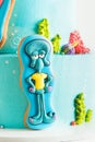Birthday cake for a fan of SpongeBob SquarePants on white background. Nautical turquoise bunk cake with characters of animated Royalty Free Stock Photo