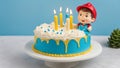 birthday cake with five 5 candles A birthday cake with a blue candle and a boy figurine in a hard hat on top.
