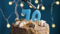 Birthday cake with 70 number candle on blue backgraund. Candles are set on fire