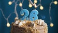 Birthday cake with 26 number candle on blue backgraund. Candles are set on fire