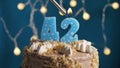 Birthday cake with 42 number candle on blue backgraund. Candles are set on fire