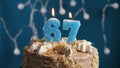 Birthday cake with 67 number candle on blue backgraund