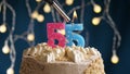 Birthday cake with 55 number pink candle on blue backgraund. Candles are set on fire Royalty Free Stock Photo