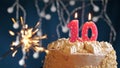 Birthday cake with 10 number pink candle and sparkler on blue backgraund Royalty Free Stock Photo