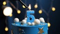 Birthday cake number 5 stars sky and moon concept, blue candle is fire by lighter. Copy space on right side of screen. Close-up Royalty Free Stock Photo