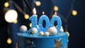 Birthday cake number 100 stars sky and moon concept, blue candle is fire by lighter. Copy space on right side of screen. Close-up Royalty Free Stock Photo