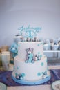 Birthday cake for one year old boy. Teddy bear cartoon character shape and blue decorations of mastic. Candy bar.