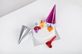 Birthday cake with party hats and noisemaker on table