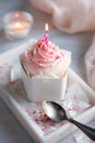 Birthday cake with pink and white icing and lit candle in a box Royalty Free Stock Photo