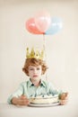 Birthday cake, portrait and balloons with sad boy by table in family home for celebration, growth and lonely. Dessert Royalty Free Stock Photo