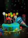 Birthday cake with red car and colorful balloons on top on the bokeh background