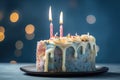 a birthday cake with three lit candles on a plate with a blurry boke of lights in the background and a blurry boke of lights in