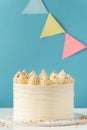 Birthday cake with white cream cheese frosting decorated with multicolored lit candles on a blue background. Happy Birthday Royalty Free Stock Photo