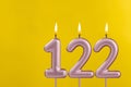 Birthday candle number 122 - Birthday celebration on yellow background