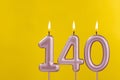 Birthday candle number 140 - Birthday celebration on yellow background