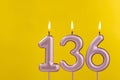 Birthday candle number 136 - Birthday celebration on yellow background