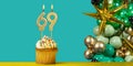 Birthday candle number 69 - Cupcake with decoration on a green background