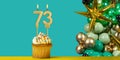 Birthday candle number 73 - Cupcake with decoration on a green background