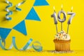 Birthday candle number 107 with cupcake - Yellow background with blue pennants