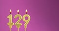 Candle number 129 in purple background - birthday card Royalty Free Stock Photo