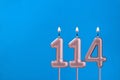 Birthday card with number 114 - Burning anniversary candle on blue background