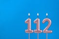 Birthday card with number 112 - Burning anniversary candle on blue background