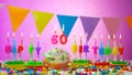 Birthday card with number 60 year. Happy birthday to a six ten year old. Candles burn with a festive cream cake. Greeting card Royalty Free Stock Photo