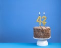 Birthday celebration with candle 42 - Chocolate cake on blue background