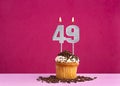 Birthday celebration with candle number 49 - Chocolate cupcake on pink background