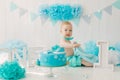 Birthday child 1 year old boy, baby sitting with blue garlands and number one in a suit and bowtie Royalty Free Stock Photo