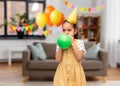 girl blowing balloon at birthday party at home Royalty Free Stock Photo