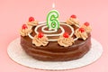 Birthday chocolate cake with burning candle in the form of number Six. Homemade cake decorated with chocolate cream and cherries Royalty Free Stock Photo