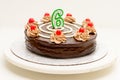 Birthday chocolate cake with candle in the form of number Six. Homemade cake decorated with chocolate cream and cherries Royalty Free Stock Photo