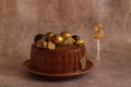 Birthday chocolate cake with gold balls and a candle with the number 5 on a beige background Royalty Free Stock Photo