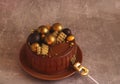 Birthday chocolate cake with gold balls and a candle with the number 5 on a beige background Royalty Free Stock Photo