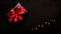 A birthday, Christmas or valentines gift, present wrapped in black paper and red ribbon Royalty Free Stock Photo