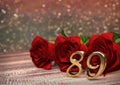 Birthday concept with red roses on wooden desk. eighty-nineth. 89th. 3D render