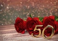 Birthday concept with red roses on wooden desk. fiftieth birthday. 50th. 3D render Royalty Free Stock Photo