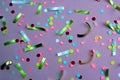 Texture festive confetti scattered on lilac background