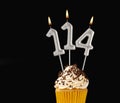 Birthday cupcake on black background - Number 114 shaped candles Royalty Free Stock Photo